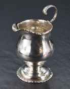 A George III silver cream jug, of helmet form with rope twist edge detail and scroll handle all over