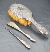 A Victorian silver mounted hair brush, having embossed foliate scrolls throughout along with