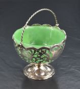 A Victorian silver sugar basket, having a pivoted and twisted over-handle above a green glass