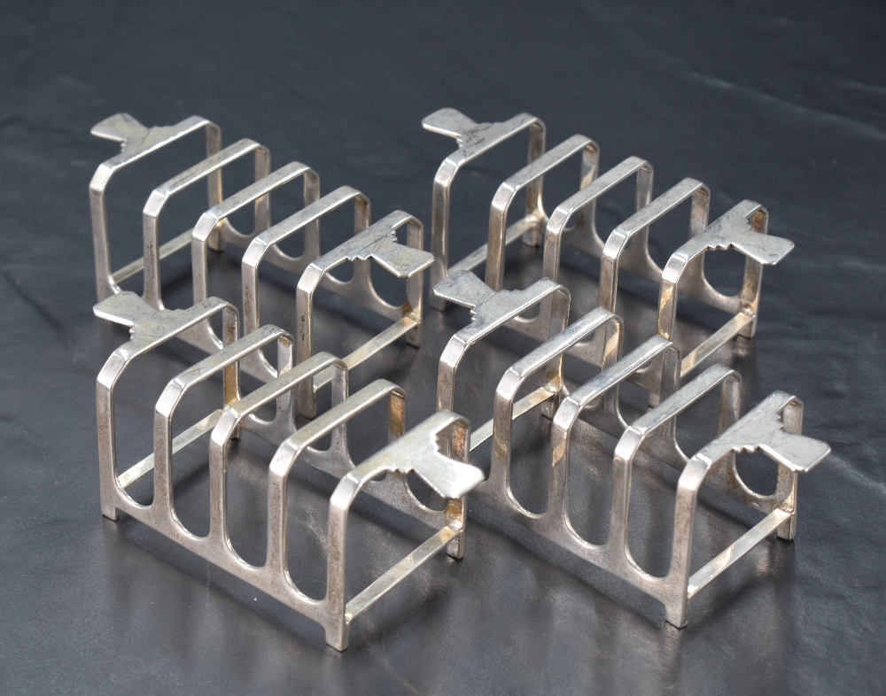 A group of four Art Deco design silver four division toast racks, each of rectangular form with