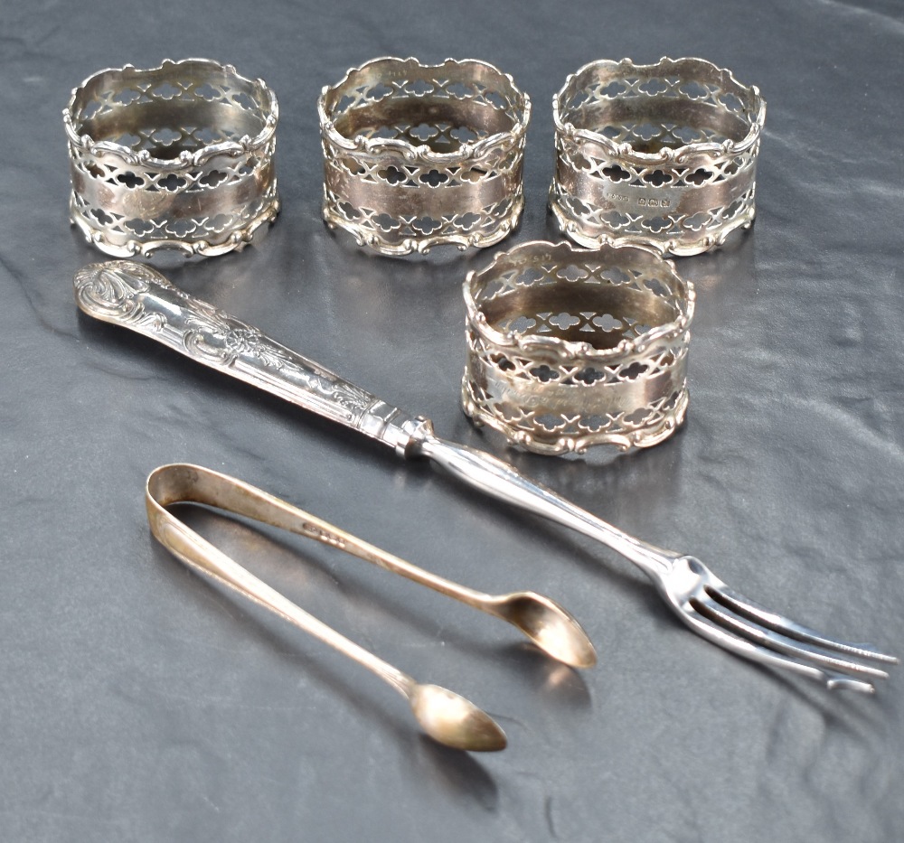 A set of four George V silver napkin rings, of oval form with moulded C-scroll and pierced