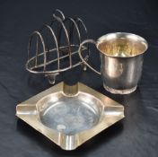 A George V silver four division toast rack, with shaped central handle and arched divisions,
