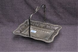 An Edwardian silver basket, of rectangular form with shaped and gadrooned edge enclosing pierced