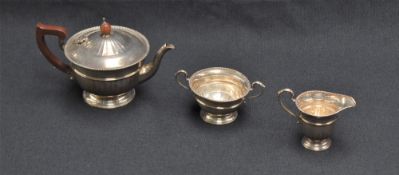 A George V silver three-piece teaset, comprising teapot, sugar and cream, each of circular form with