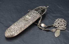 A late Victorian silver spectacle case, of rounded oblong form with typical embossed foliate and C-