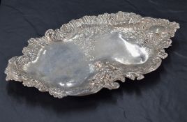 A late Victorian imported silver tray, of shaped oval form and embossed with a seated putto