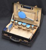 A George V stitched and stained leather vanity case having gilt tooled initials M.R.L and outer