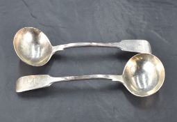 A pair of Victorian silver fiddle pattern sauce ladles, engraved with arm and sword crest, marks for