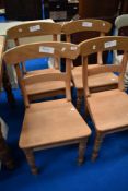 A set of four Georgian style stripped solid seat dining chairs