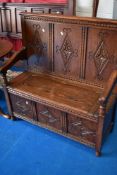 An early to mid 20th Century oak box settle having carved panel decoration, of nice proportions,
