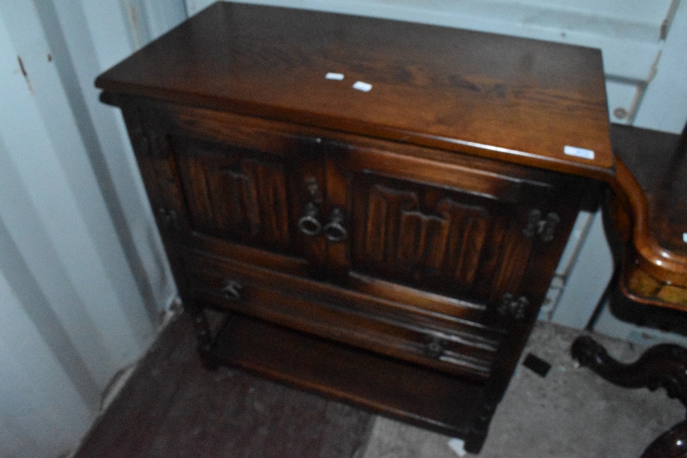 An Old Charm/Priory style side cabinet having linen fold doors and stile frame