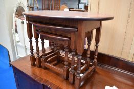 An Old Charm nest of three tables, retailed by Wood Brothers Limited, the largest with oval top