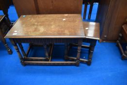 A vintage Priory style nest of one large and two smaller occasional tables