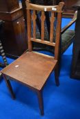 An Arts and Crafts style solid seat hall or dining chair in golden oak