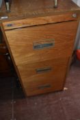A vintage teak effect three drawer filing cabinet, labelled Abbess