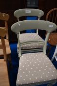 Two painted dining chairs having upholstered drop in seats