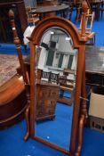 A reproduction cheval wall mirror having classical style frame