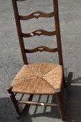 A traditional rush seated ladder back rocking chair