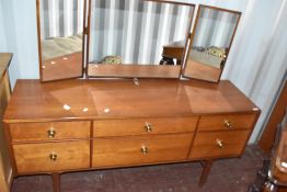 A vintage teak and laminate dressing table, having triple mirror over three shallow and three deep