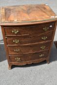 A reproduction walnut fronted four drawer chest