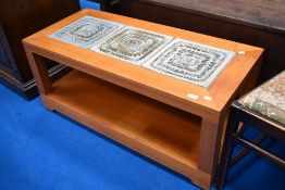A vintage teak coffee table having studio pottery type design to top and castors to base