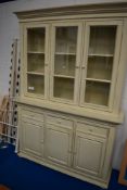 A modern neutral painted book or display cabinet having sideboard base, dimensions approx. W154cm