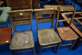 A pair of vintage chapel chairs and a similar solid seat railback chair