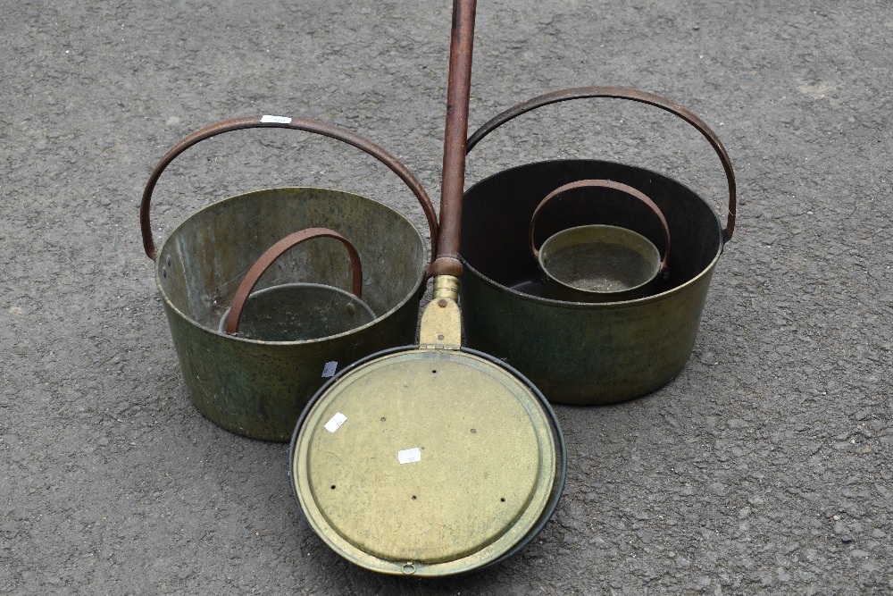 A selection of brass jam pans and bed warming pan