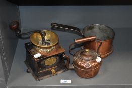 A vintage cast metal and brass coffee grinder, a copper pan and a small kettle.