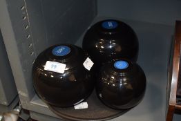 Three weighted plastic carpet bowls.