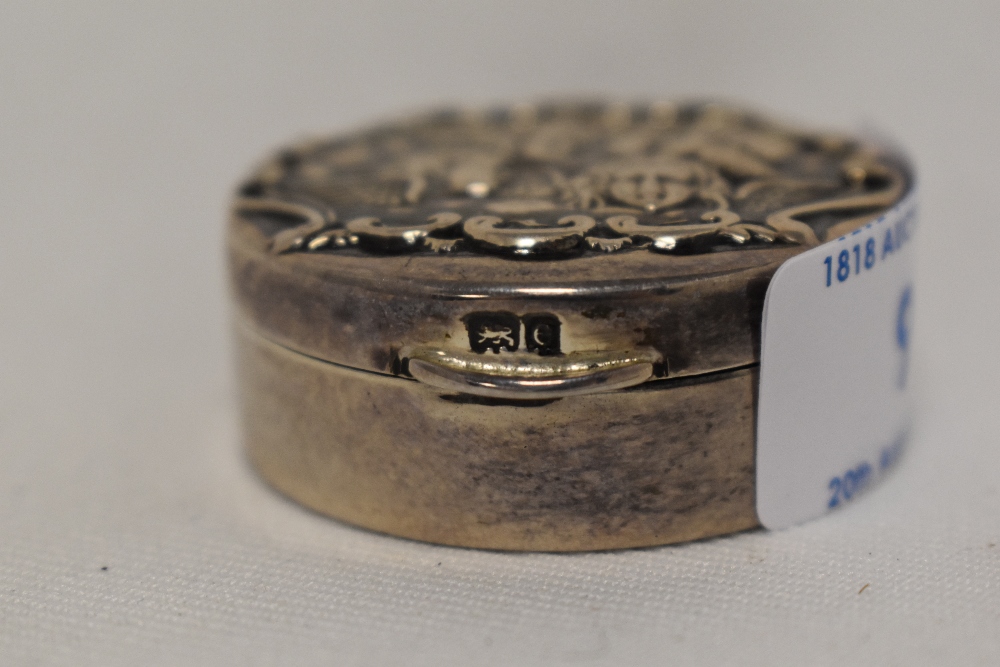 A small Edwardian silver circular dressing table box, the cover embossed with cherubs, marks to - Image 2 of 2