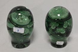 Two Victorian 'end of day' green glass dump weights, each with floral sulphide inclusions,