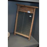 A vintage glass and wood washboard.