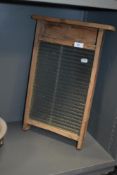 A vintage glass and wood washboard.