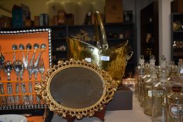 A vintage brass coal helmet and a castcraft cast metal mirror, having gold tone finish.