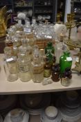 A collection of antique apothecary and pharmaceutical glass bottles, including green and amber