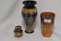 A Royal Doulton stoneware baluster vase with repeating moulded foliate decoration against a