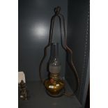 A vintage brass stable lamp with bracket, having glass chimney.