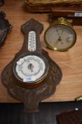 An antique carved oak Aneroid barometer having Arts and Crafts styling, sold alongside a brass cased