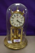 A vintage anniversary clock with glass dome having some discoloration to base.