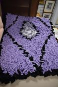 An as new, handmade peggy/ proddy rug in purple, black and white.
