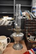A 1930s Aladdin oil lamp, with glass chimney, measuring 60cm tall