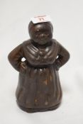 An early 20th Century cast metal money bank, of Aunt Jemima, measuring 18cm tall