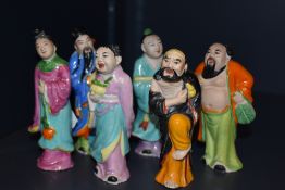 Six glazed pottery Chinese figural ornaments, hand painted and to represent the eight immortals,