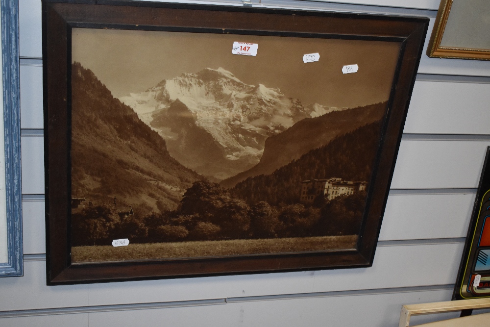 A sepia tone photographic print of an Alpine mountain view, displayed in a 20th Century oak frame,