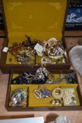 A vintage studded leatherette jewellery box containing an assorted collection of costume
