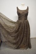 A 1950s Jean Allen taupe coloured evening gown with a slight gold sheen, having full sheer top layer