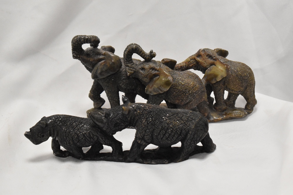Two 20th Century stone carved and textured rhinoceros and elephant ornaments, the largest
