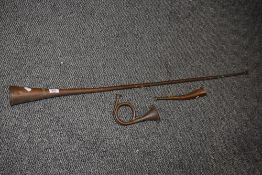 Three 19th Century copper and brass hunting horns, the largest measuring 120cm long