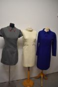 Three 1960s dresses, including grey mini dress and white shift dress with beaded detail.